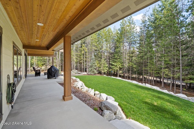 view of patio featuring grilling area and a view of trees