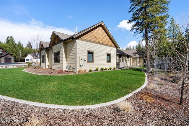 view of side of property featuring cooling unit, a lawn, and roof with shingles