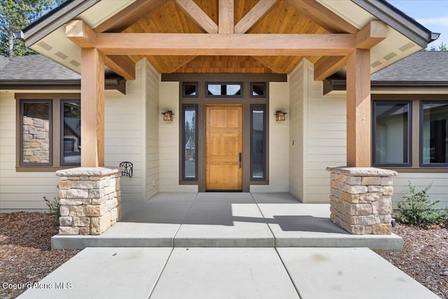 property entrance with a porch and a shingled roof