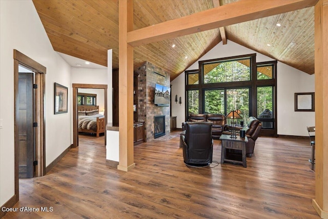 living area featuring high vaulted ceiling, a large fireplace, wooden ceiling, wood finished floors, and beam ceiling
