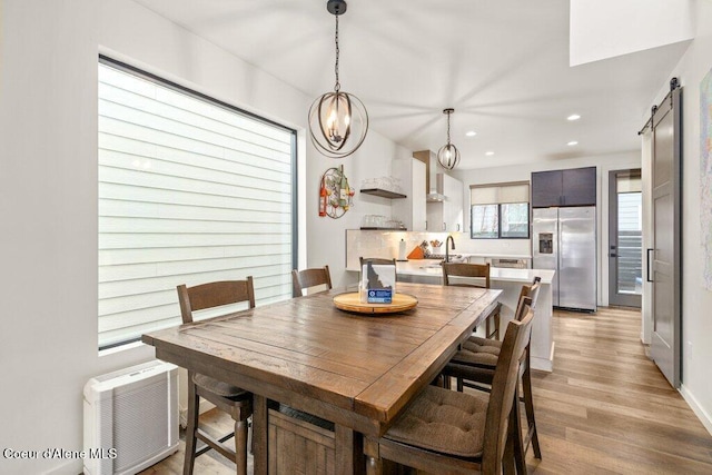 3242 N Rosalia Rd, Coeur Dalene, ID 83814 - dining area with light wood-type flooring, recessed lighting, an inviting chandelier, and a barn door