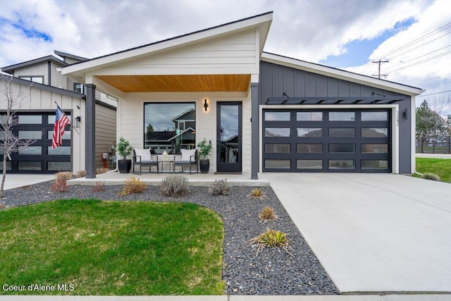 3242 N Rosalia Rd, Coeur Dalene, ID 83814 - view of front of house featuring board and batten siding, a porch, a garage, and concrete driveway