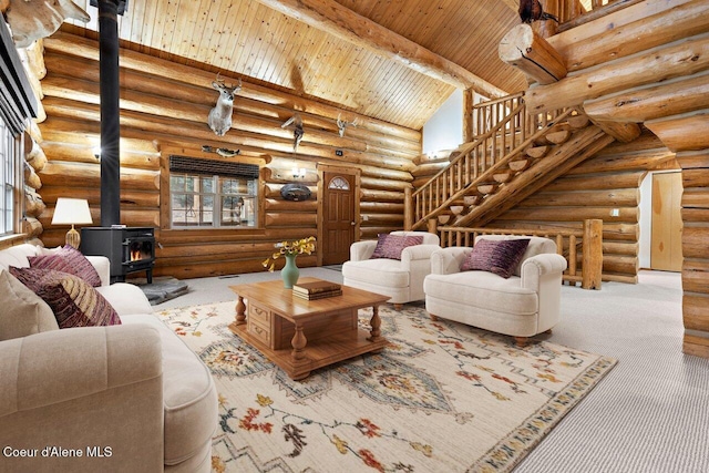 living room with rustic walls, stairway, wood ceiling, a wood stove, and high vaulted ceiling