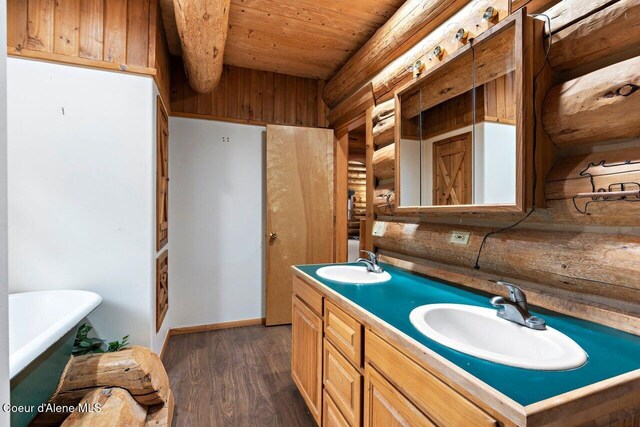 bathroom featuring a soaking tub, wooden ceiling, wood finished floors, and a sink