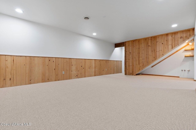 finished basement featuring visible vents, a wainscoted wall, wooden walls, recessed lighting, and carpet