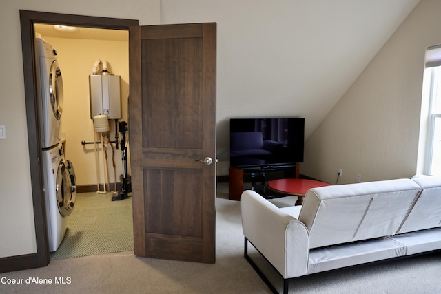 carpeted living room featuring stacked washer / dryer, baseboards, tankless water heater, and vaulted ceiling