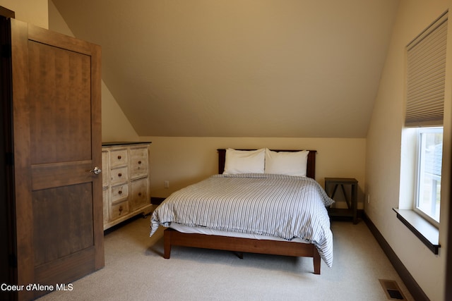 carpeted bedroom with visible vents, baseboards, and vaulted ceiling