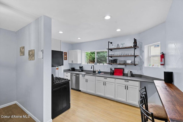 804 Residence St, Wallace, ID 83873 - kitchen with white cabinets, baseboards, a sink, light wood-type flooring, and stainless steel dishwasher