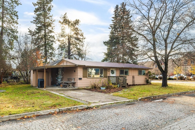 single story home with a front yard, driveway, metal roof, and a carport