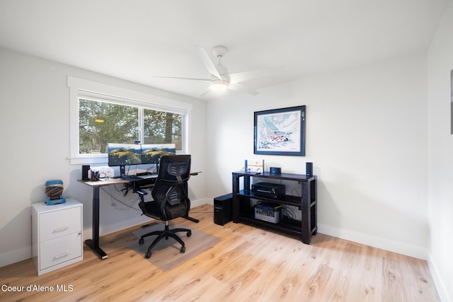 home office featuring light wood-style flooring, baseboards, and a ceiling fan