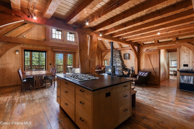 kitchen with wooden ceiling, wooden walls, hardwood / wood-style floors, and dark countertops