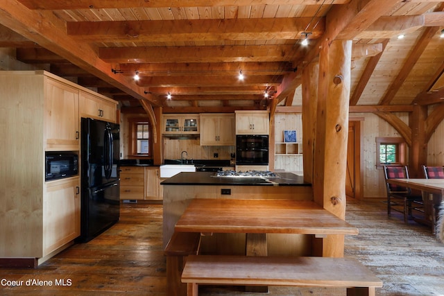 kitchen with light brown cabinets, dark countertops, dark wood-type flooring, beam ceiling, and black appliances