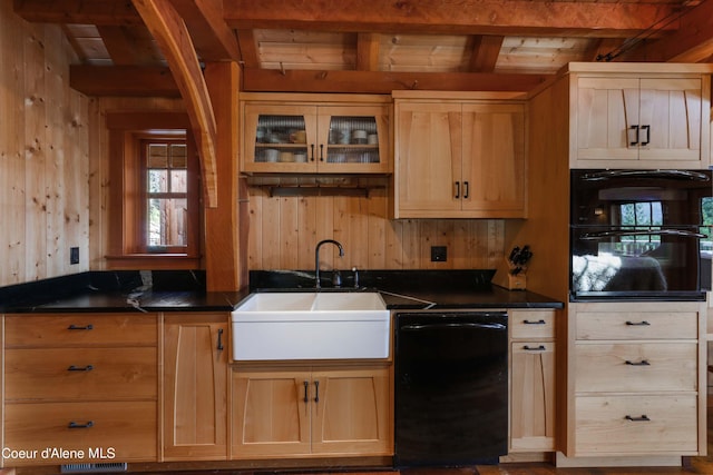 kitchen featuring wood walls, beamed ceiling, a sink, and black appliances