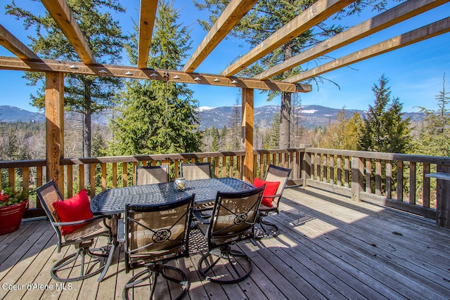 wooden deck featuring a mountain view and outdoor dining space