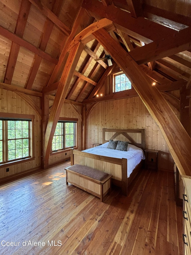unfurnished bedroom with wood-type flooring and wooden walls