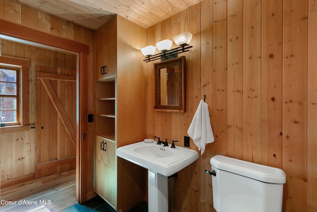 bathroom featuring toilet, wood ceiling, wood finished floors, and wooden walls