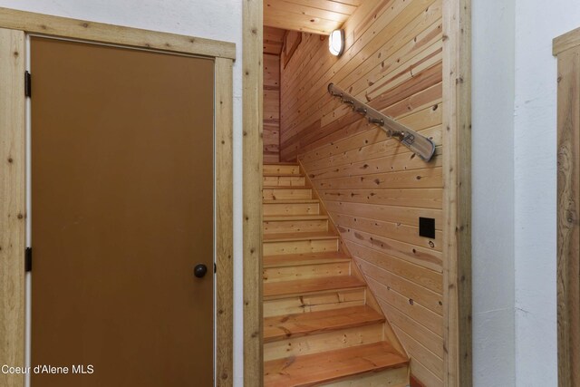 staircase featuring wood walls