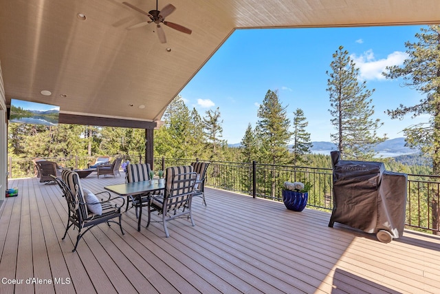 1122 S Four Winds Rd, Coeur Dalene, ID 83814 - wooden deck with area for grilling, outdoor dining space, a mountain view, and a ceiling fan