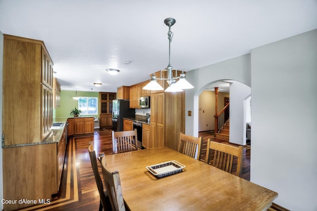 234 Stoneridge Rd, Blanchard, ID 83804 - dining area with stairway, arched walkways, and dark wood-type flooring