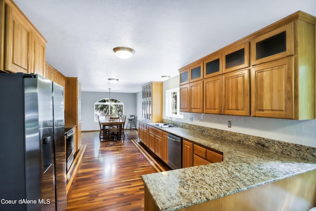 234 Stoneridge Rd, Blanchard, ID 83804 - kitchen featuring glass insert cabinets, dark wood-style flooring, appliances with stainless steel finishes, a peninsula, and light stone counters