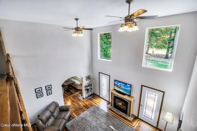 234 Stoneridge Rd, Blanchard, ID 83804 - living room featuring a ceiling fan, arched walkways, wood finished floors, and a lit fireplace