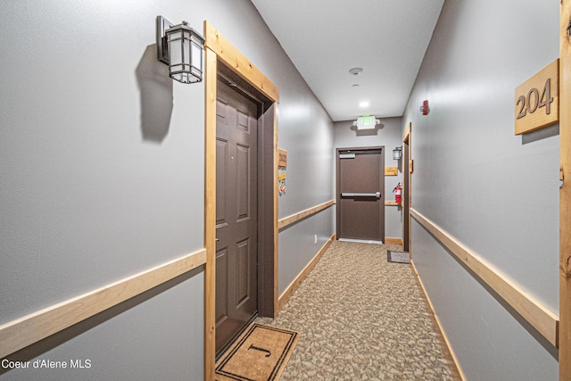 hall featuring baseboards and carpet