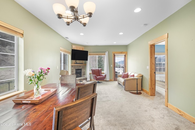 living area featuring baseboards, a chandelier, a fireplace, light carpet, and recessed lighting