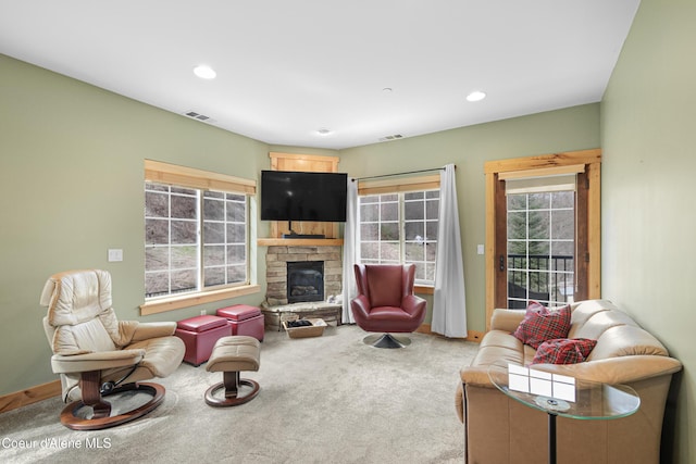 carpeted living area with baseboards, a fireplace, visible vents, and recessed lighting