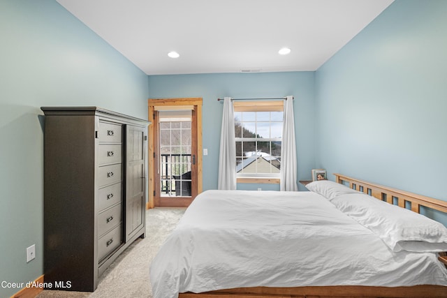 bedroom with access to exterior, light colored carpet, and recessed lighting