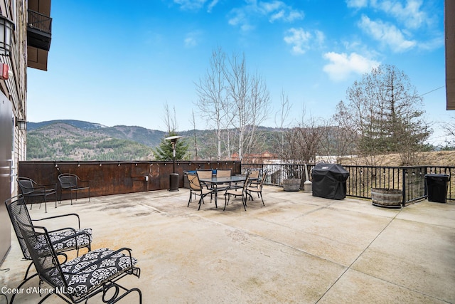 view of patio featuring outdoor dining area, a mountain view, and area for grilling