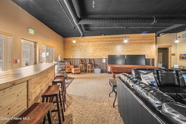 living area featuring wooden walls, visible vents, and carpet floors