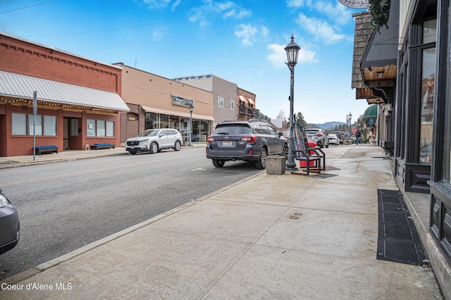 view of road with street lights, curbs, and sidewalks