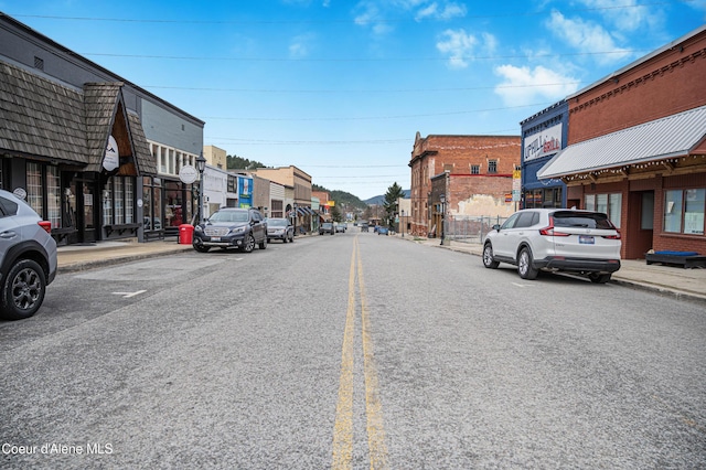 view of street featuring street lighting, sidewalks, and curbs