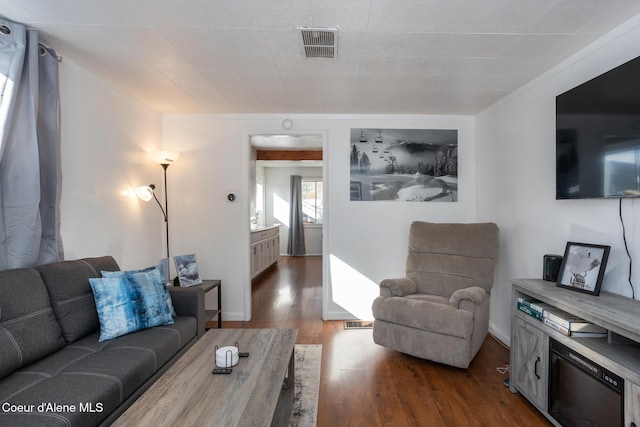 living area with visible vents and dark wood-style floors