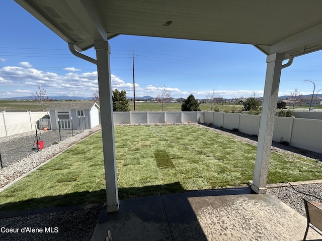 view of yard with a fenced backyard and an outbuilding