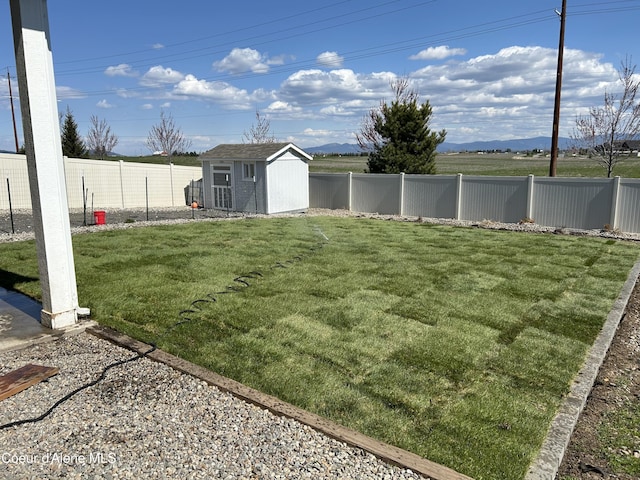 view of yard featuring a fenced backyard, a storage shed, and an outbuilding
