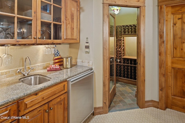 16917 S Basalt Dr, Coeur Dalene, ID 83814 - kitchen featuring light stone counters, stainless steel dishwasher, glass insert cabinets, and brown cabinets