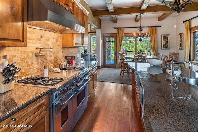 16917 S Basalt Dr, Coeur Dalene, ID 83814 - kitchen with exhaust hood, range with two ovens, dark wood-style floors, brown cabinets, and decorative backsplash