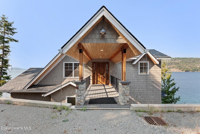view of front of house featuring a water view and a shingled roof