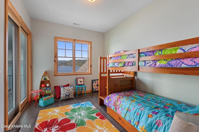 bedroom featuring wood finished floors, baseboards, and visible vents