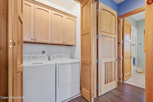 washroom with washing machine and dryer, dark wood-style floors, and cabinet space