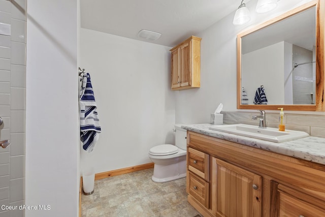 full bathroom with toilet, stone finish floor, vanity, and baseboards