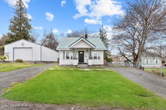315 S 5th St, Saint Maries, ID 83861 - bungalow with metal roof, a garage, a chimney, fence, and a front lawn