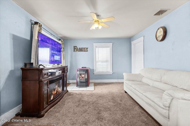 315 S 5th St, Saint Maries, ID 83861 - living area featuring baseboards, a ceiling fan, carpet floors, a wood stove, and visible vents