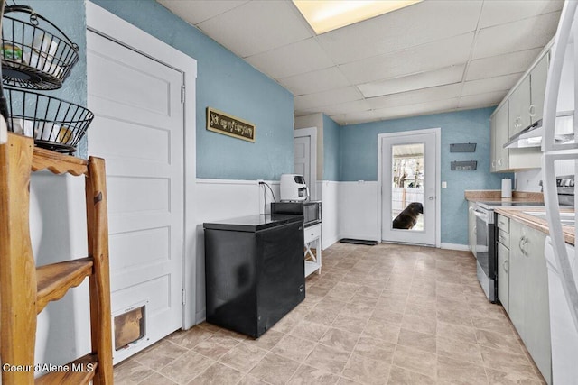 315 S 5th St, Saint Maries, ID 83861 - kitchen featuring light countertops, electric stove, under cabinet range hood, refrigerator, and a drop ceiling