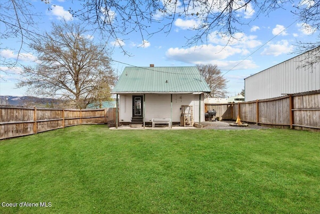 315 S 5th St, Saint Maries, ID 83861 - back of house with a fenced backyard, a lawn, entry steps, metal roof, and a chimney