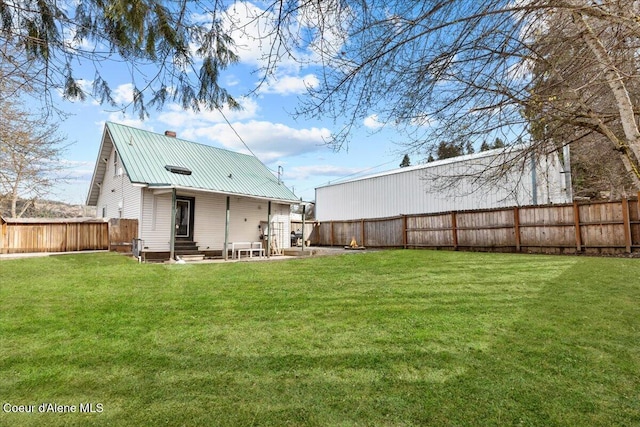 315 S 5th St, Saint Maries, ID 83861 - back of property with entry steps, a fenced backyard, metal roof, and a lawn