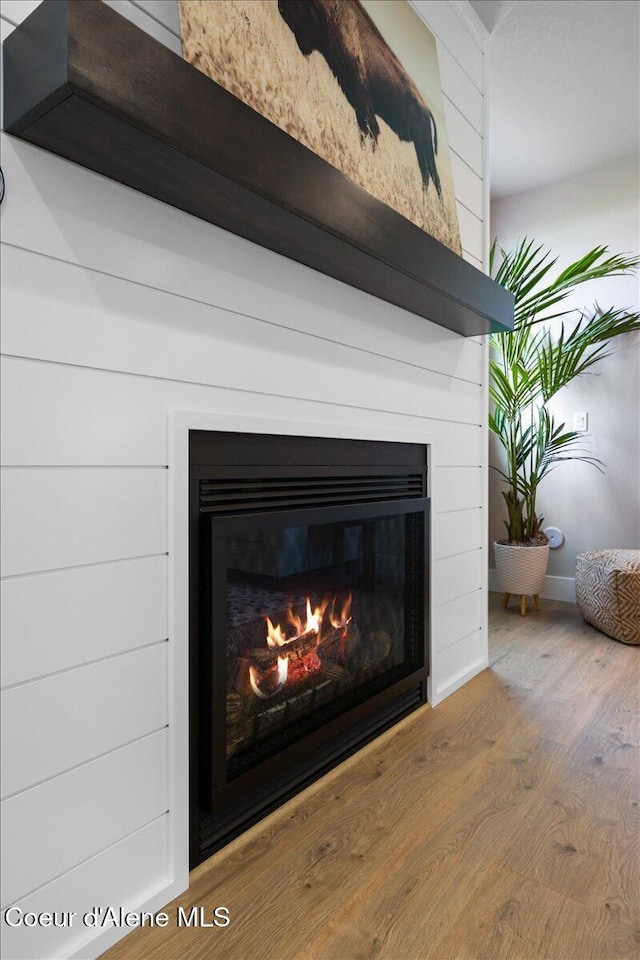 3402 N Cyprus Fox Loop, Post Falls, ID 83854 - interior details featuring a glass covered fireplace, baseboards, and wood finished floors