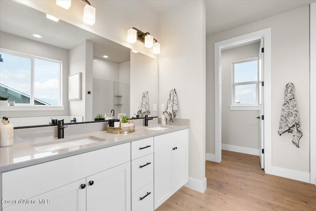 3402 N Cyprus Fox Loop, Post Falls, ID 83854 - full bathroom featuring baseboards, a sink, wood finished floors, and tiled shower