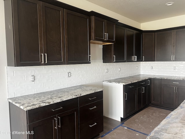 3402 N Cyprus Fox Loop, Post Falls, ID 83854 - kitchen with decorative backsplash, light stone countertops, and dark brown cabinetry